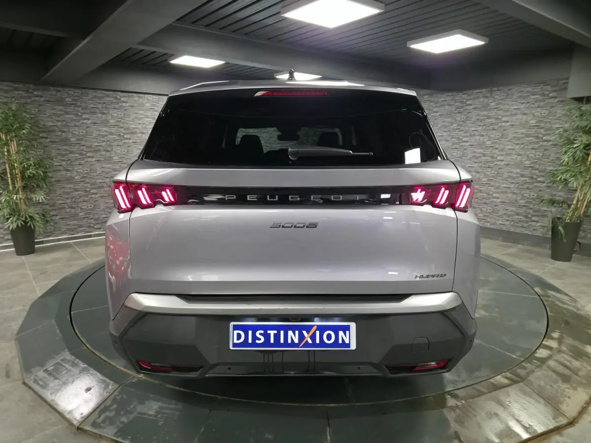 Vue arrière d'un Peugeot 5008 gris métallisé 2025 avec feux arrière LED à 3 griffes et bandeau noir laqué.