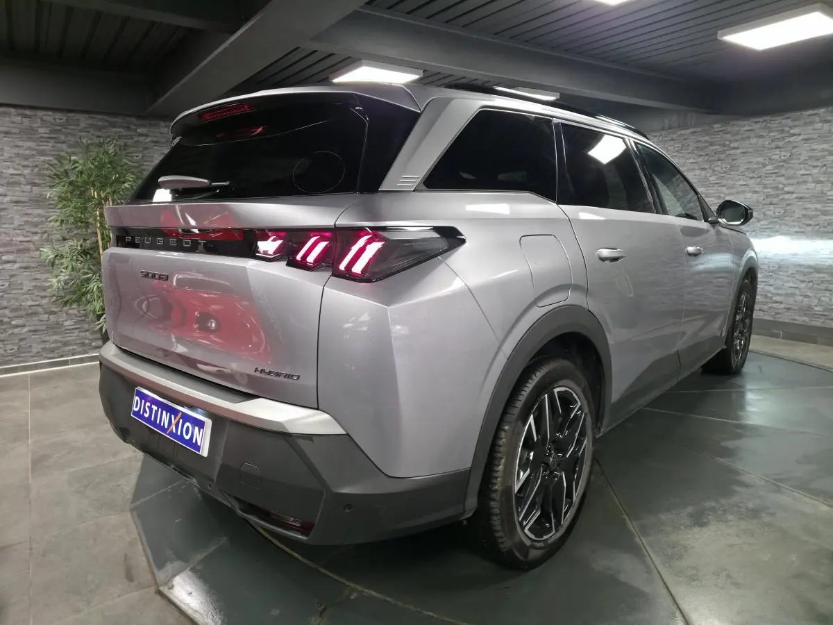 Vue 3/4 arrière droite du Peugeot 5008 gris métallisé avec feux arrière LED à 3 griffes et jantes alliage 19 pouces.