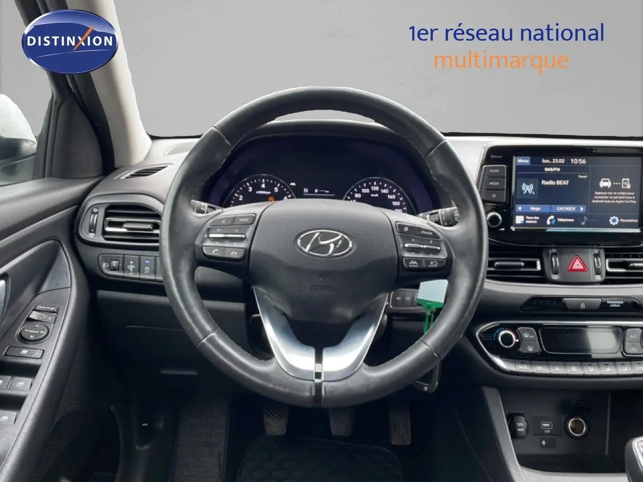 Vue intérieure centrée sur le volant noir de la Hyundai i30 SW 2021 avec tableau de bord et écran tactile visibles.