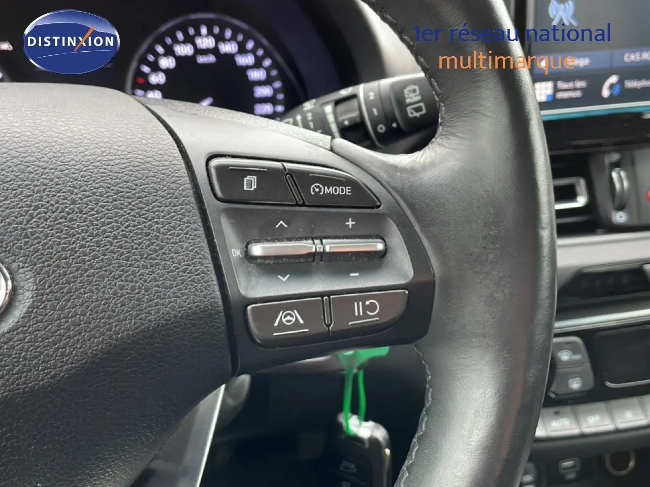 Gros plan sur le volant en cuir noir de la Hyundai i30 SW 2021, avec commandes intégrées et tableau de bord en arrière-plan.