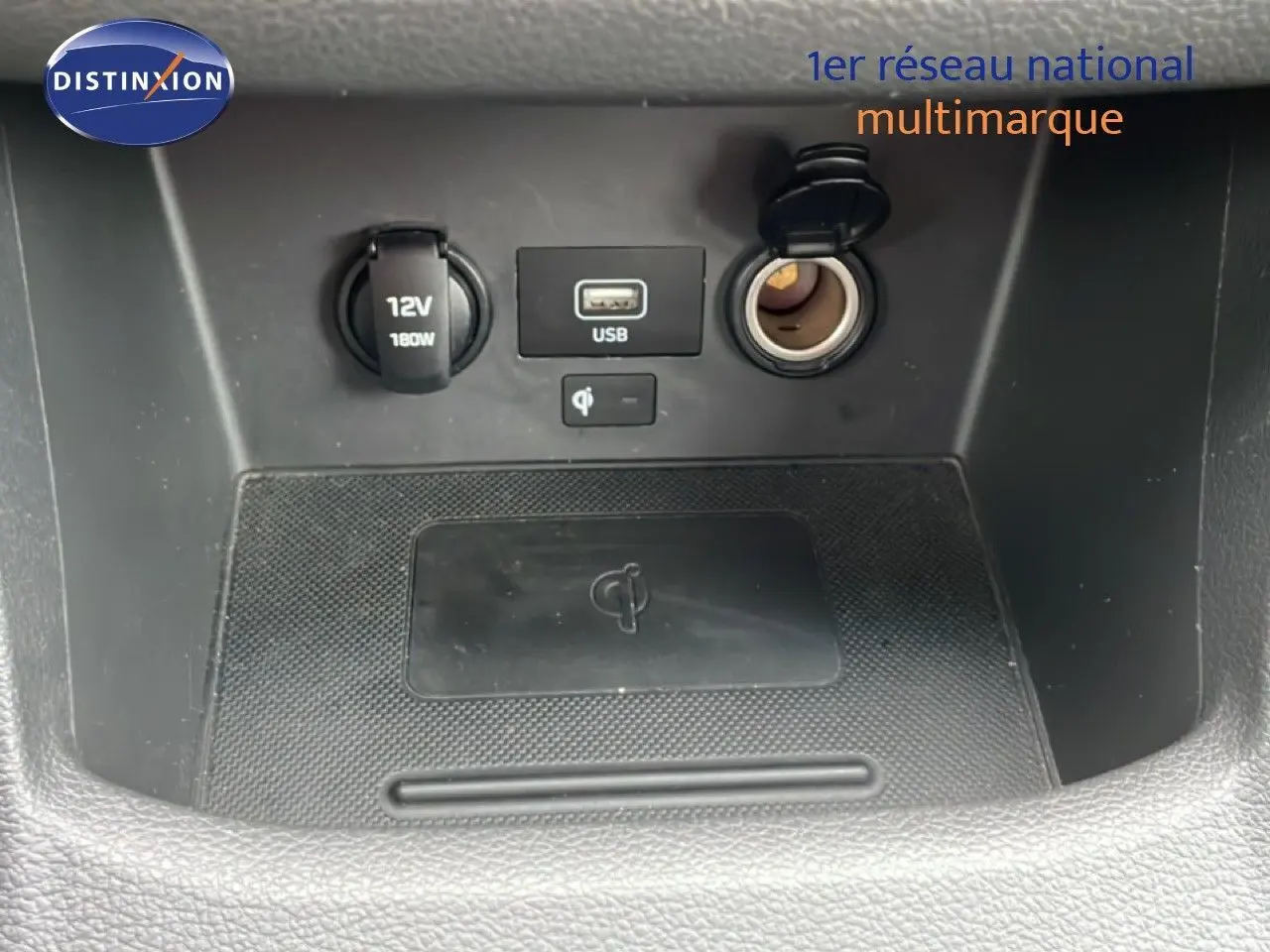 Gros plan sur la console centrale de la Hyundai i30 SW 2021, montrant prises USB, allume-cigare et chargeur sans fil.
