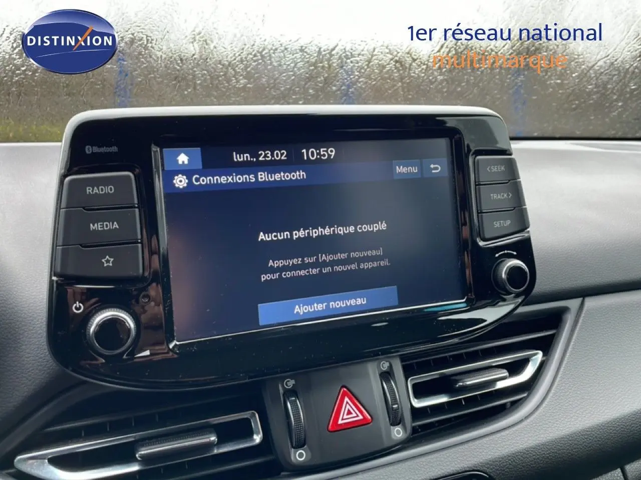 Vue rapprochée de l’écran tactile central et des commandes du tableau de bord d’une Hyundai i30 SW blanc polaire 2021.