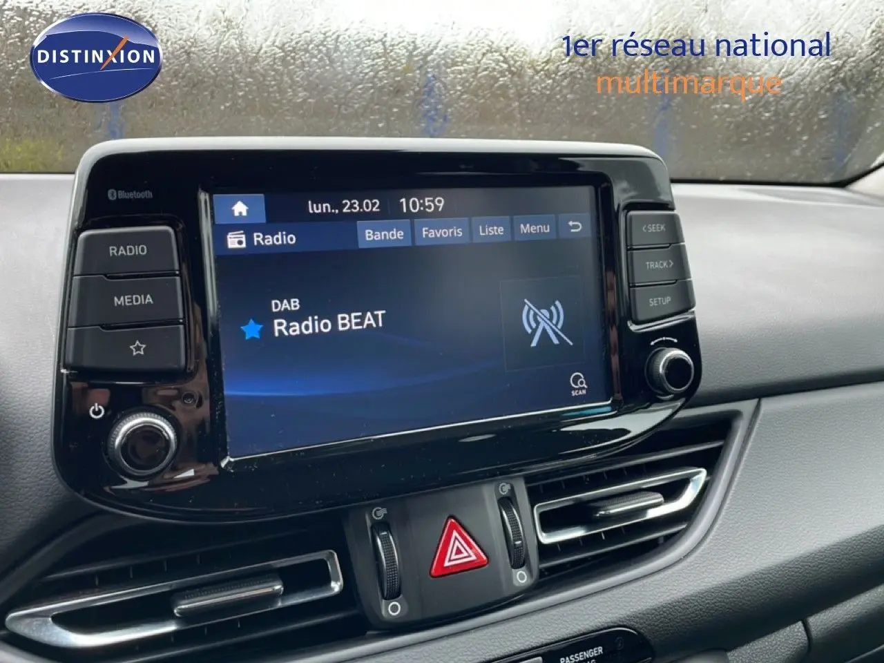 Vue rapprochée de l'écran multimédia central et des commandes de ventilation d'une Hyundai i30 SW blanche polaire de 2021.