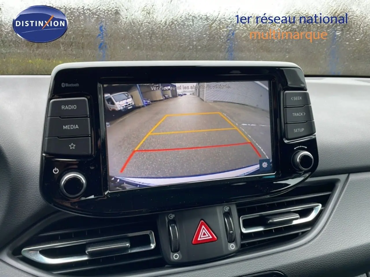 Vue rapprochée de l'écran central affichant la caméra de recul d'une Hyundai i30 SW blanche polaire.