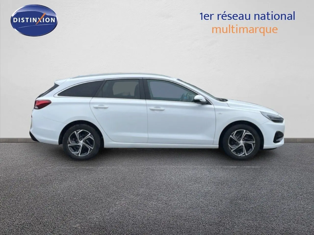 Vue de profil côté gauche d'une Hyundai i30 SW blanc polaire avec jantes alliage et vitres teintées.