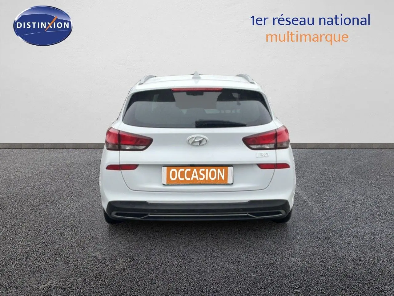 Vue arrière d'une Hyundai i30 SW blanche polaire, avec feux arrière rouges et plaque "OCCASION" visible.