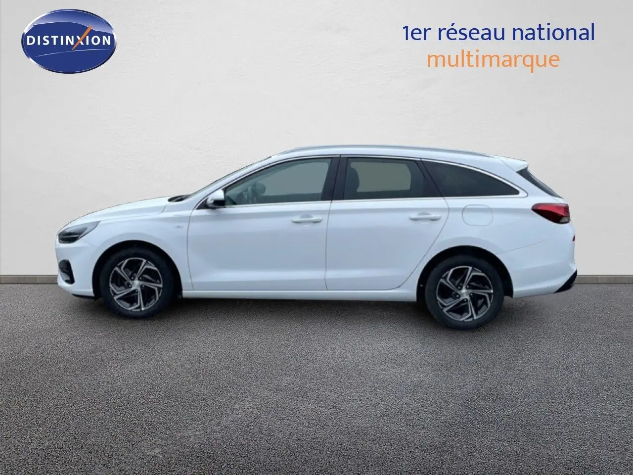 Vue latérale droite d'une Hyundai i30 SW blanche polaire, break compact avec jantes alliage et vitres teintées.