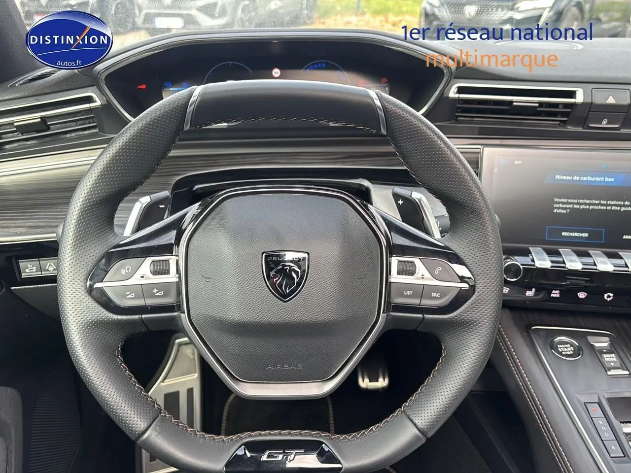 Vue rapprochée du volant cuir multifonction Peugeot 508 SW Hybrid 225 GT avec tableau de bord et écran tactile.