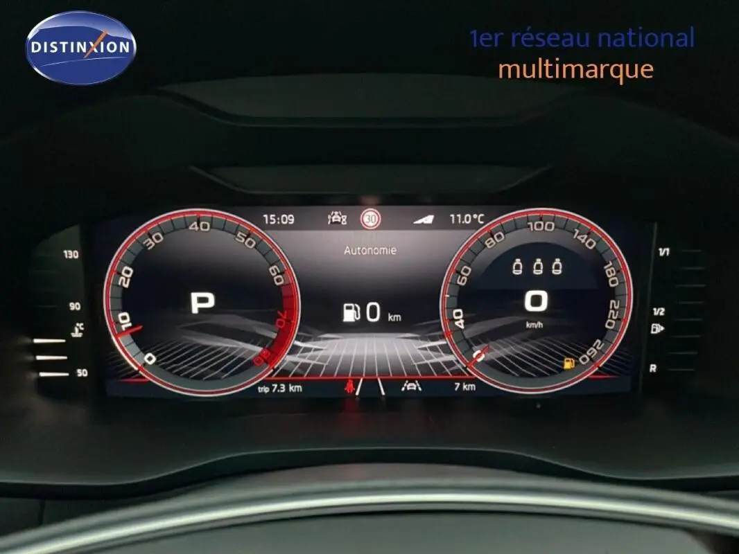 Vue en gros plan du tableau de bord numérique du Skoda Karoq argent, affichant la vitesse et le mode parking.