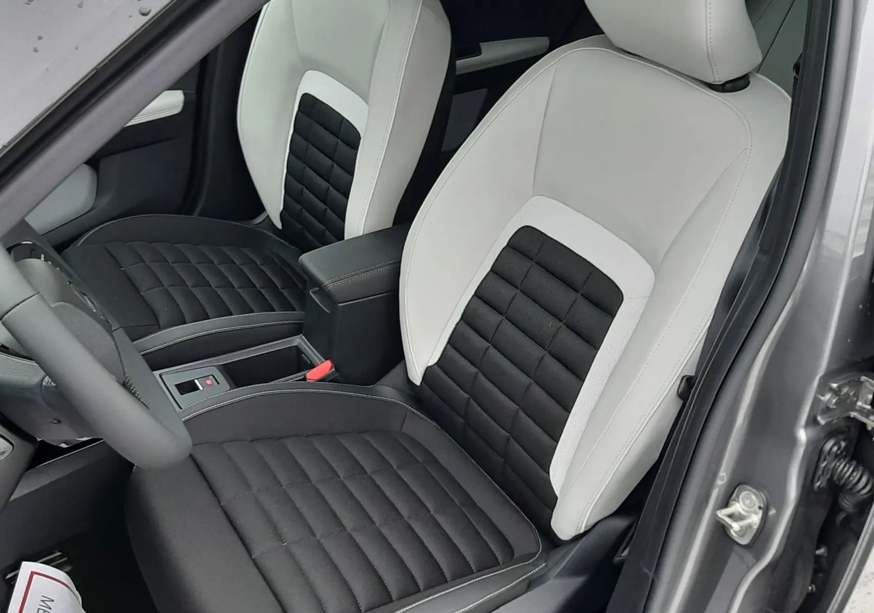 Vue intérieure côté conducteur du Citroën C3 Aircross gris Mercury 2026, sièges bicolores noir et blanc avec surpiqûres.