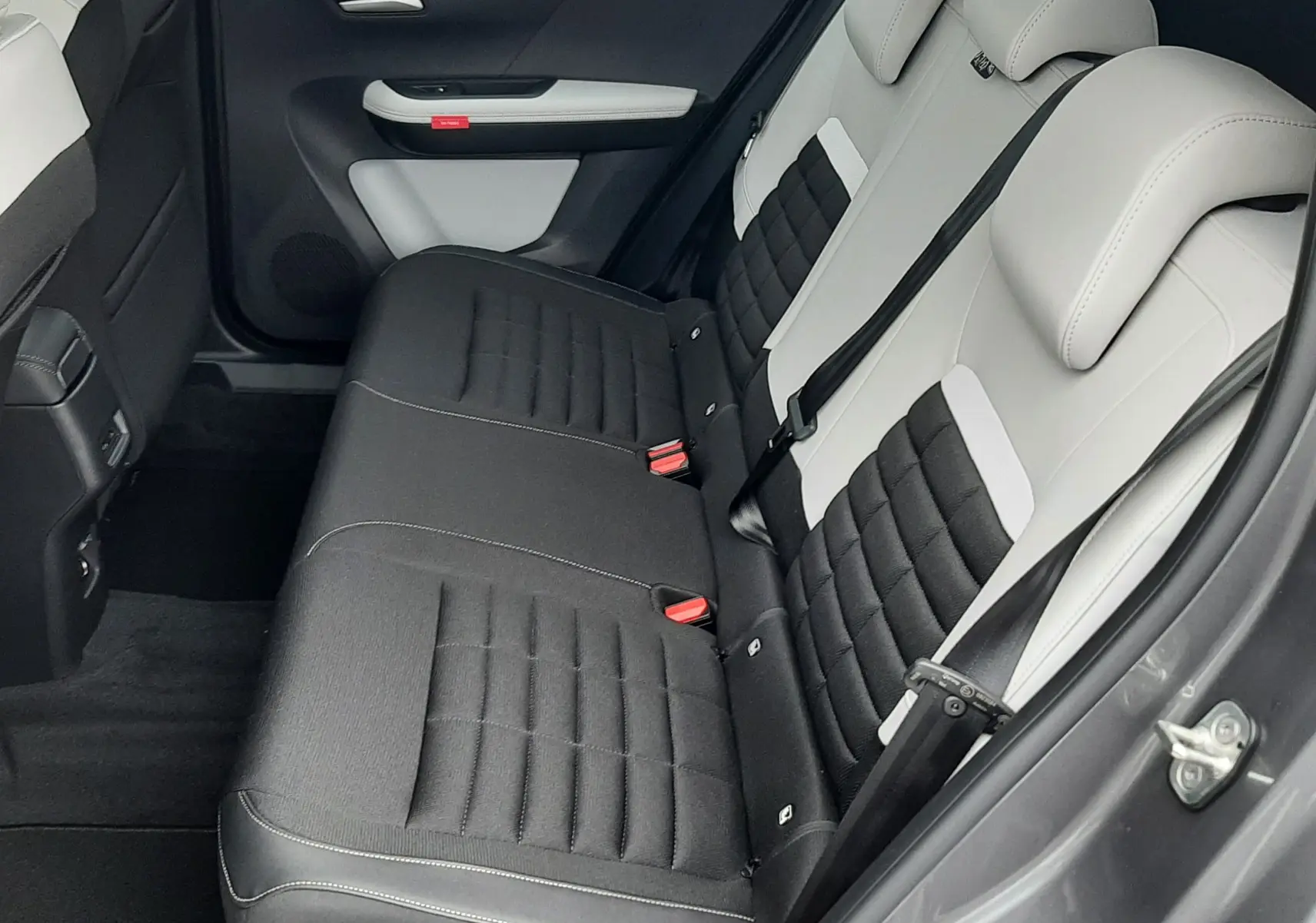 Vue côté droit de l'intérieur arrière du Citroën C3 Aircross 2026 gris Mercury, sièges bicolores noir et clair.
