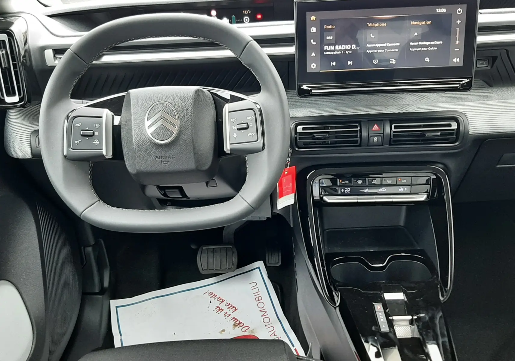 Vue intérieure centrée sur le volant et la console centrale du Citroën C3 Aircross 1.2 Hybrid 145 gris Mercury, écran tactile visible.