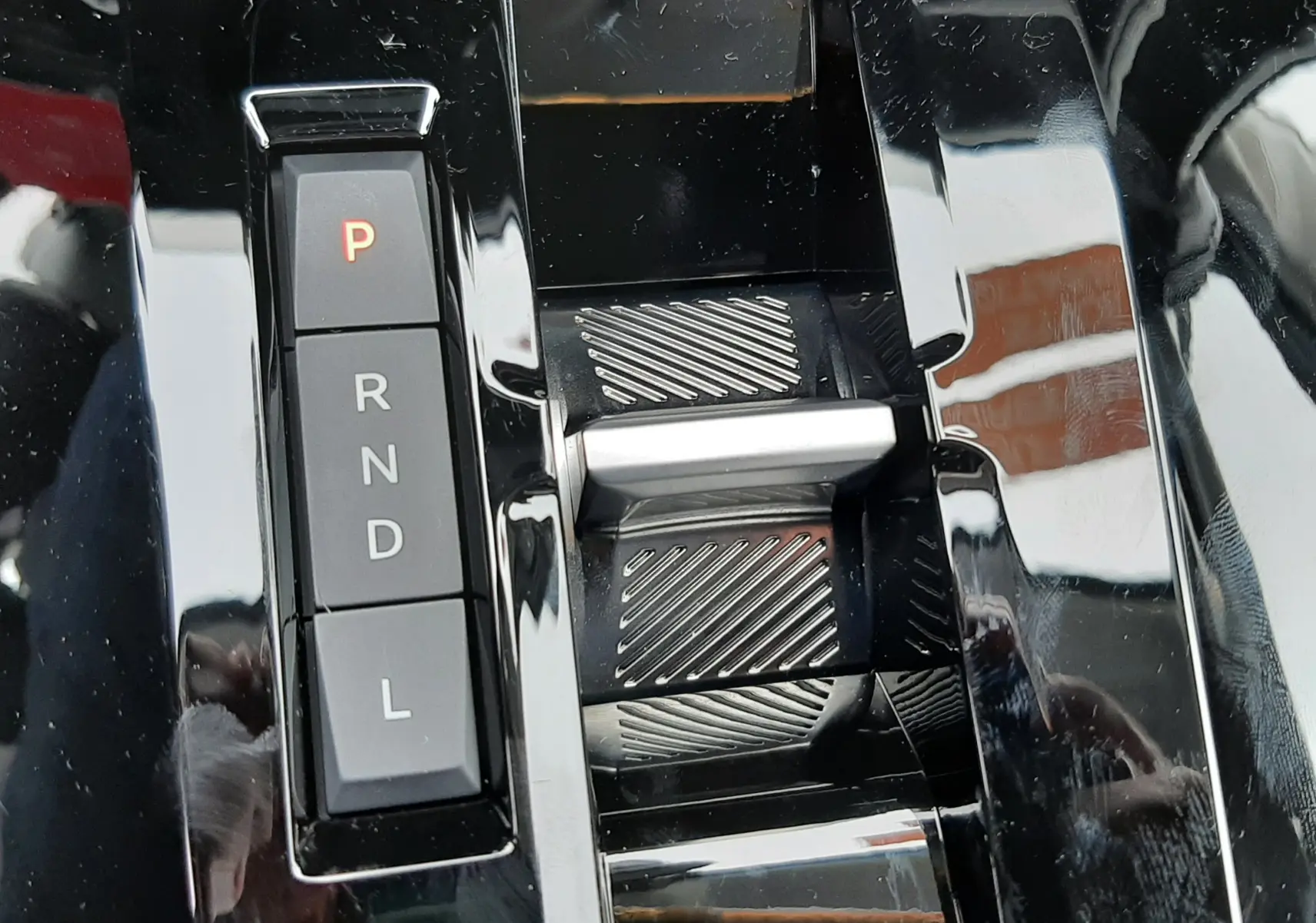 Gros plan sur la commande de boîte automatique noire du Citroën C3 Aircross gris Mercury, avec sélecteur électronique et boutons P, R, N, D, L.