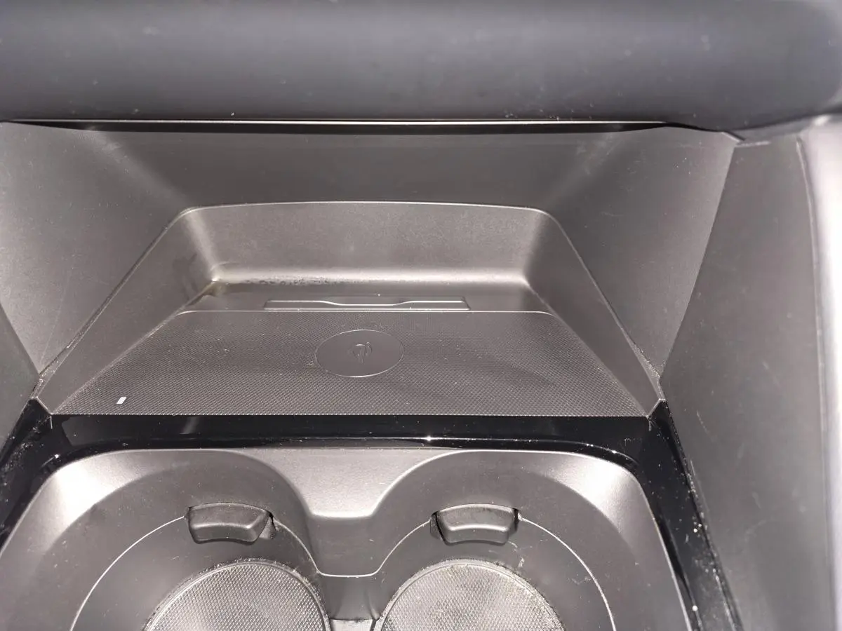 Gros plan sur le chargeur à induction et porte-gobelets noirs dans l'habitacle de la Mazda3 2024.