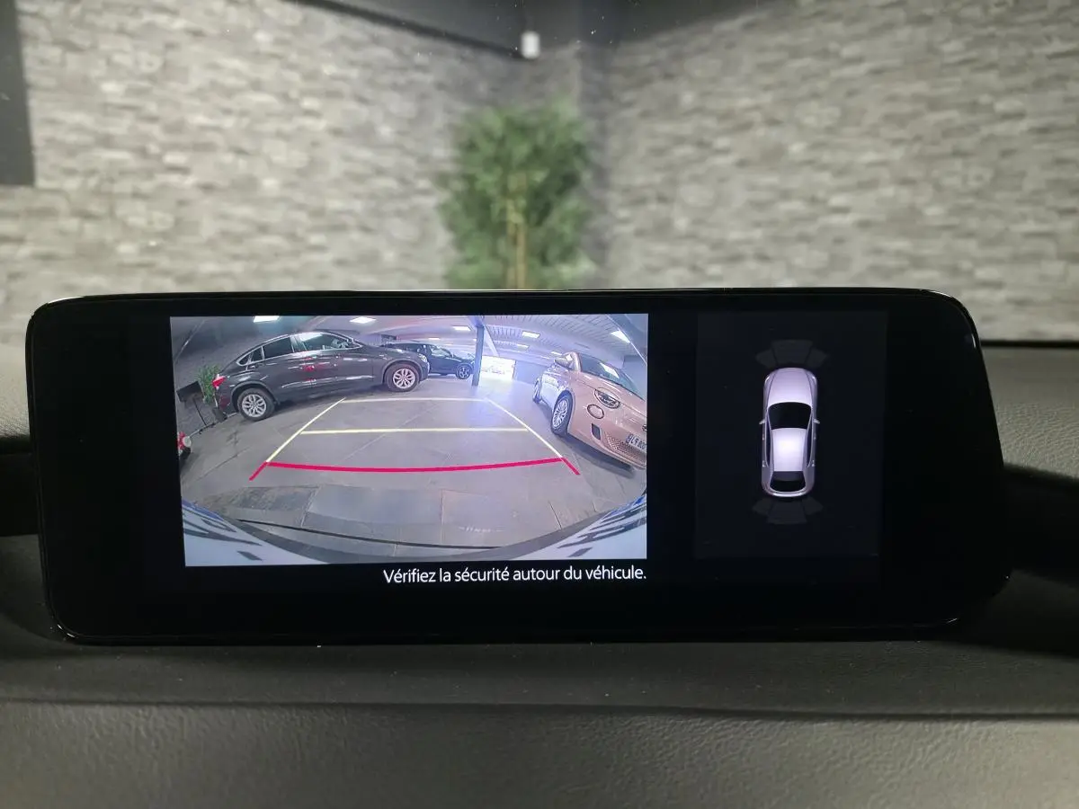 Affichage caméra de recul et capteurs de stationnement du tableau de bord d’une Mazda3 bleu 2024.