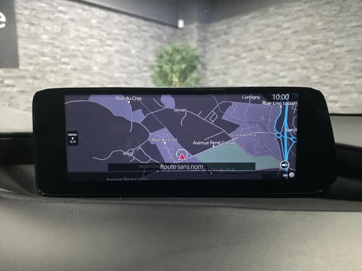 Écran central de navigation couleur dans l’habitacle d’une Mazda3 2024, affichant une carte détaillée.