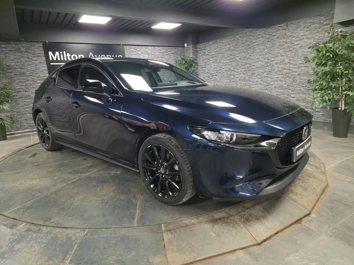 Vue 3/4 avant droite d'une Mazda3 2024 bleu métallisé avec jantes alliage noires et calandre Gloss Black.