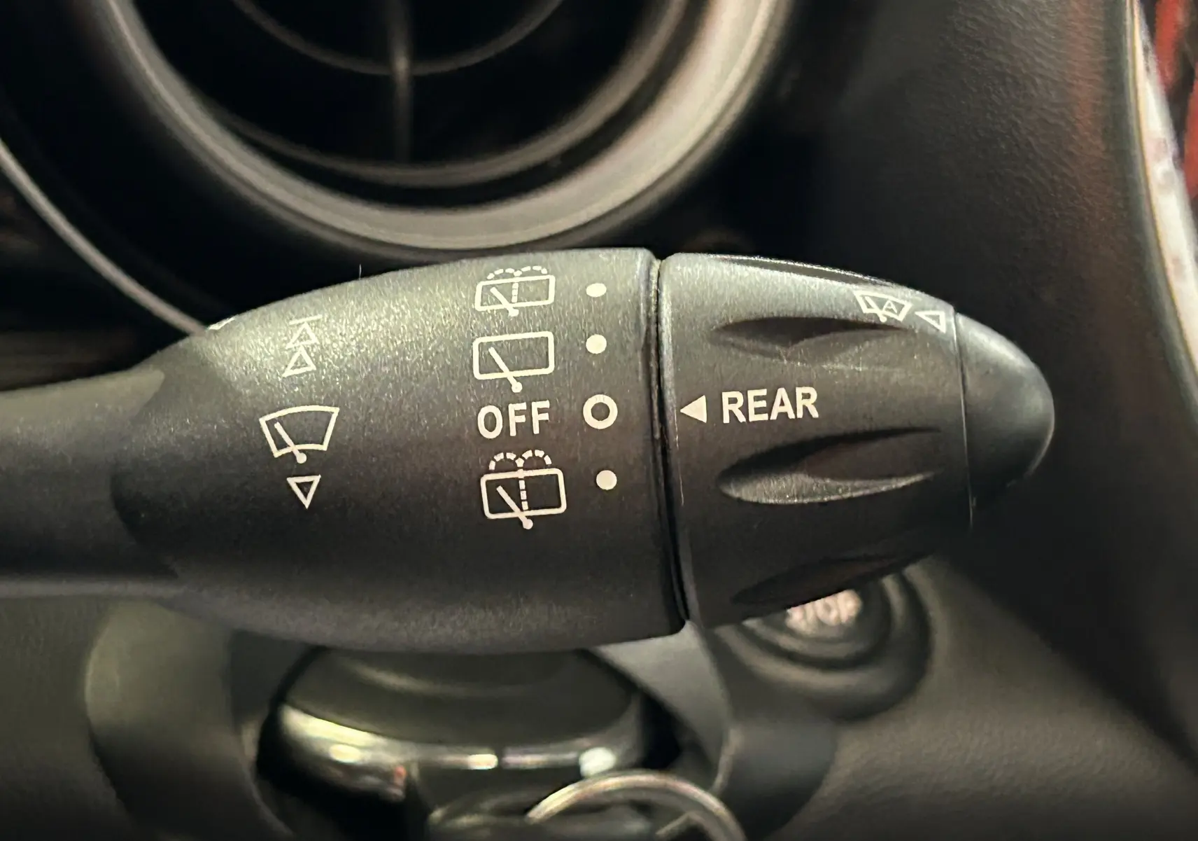 Gros plan sur la commande d'essuie-glace de la MINI Cooper gris, avec indications pour le nettoyage arrière.