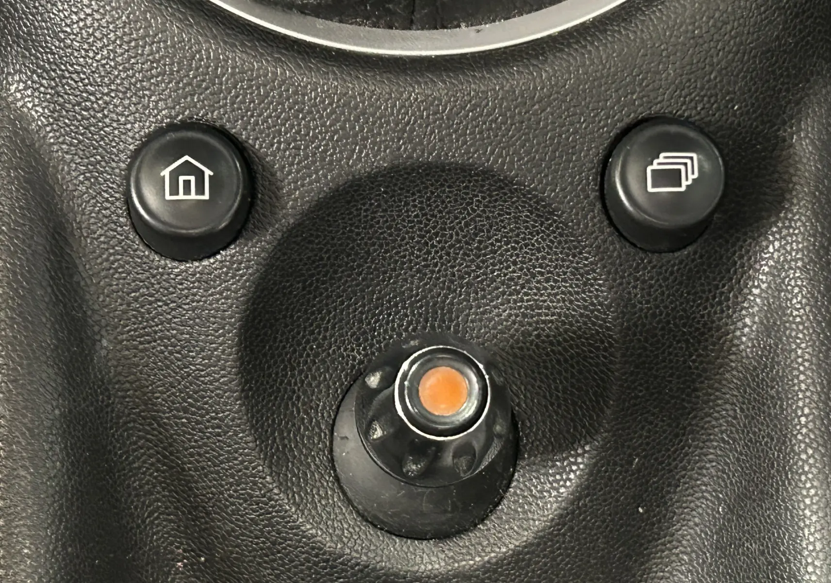 Gros plan sur les boutons de commande du tableau de bord noir d’une MINI Cooper gris 2011, avec icônes maison et fenêtres superposées.