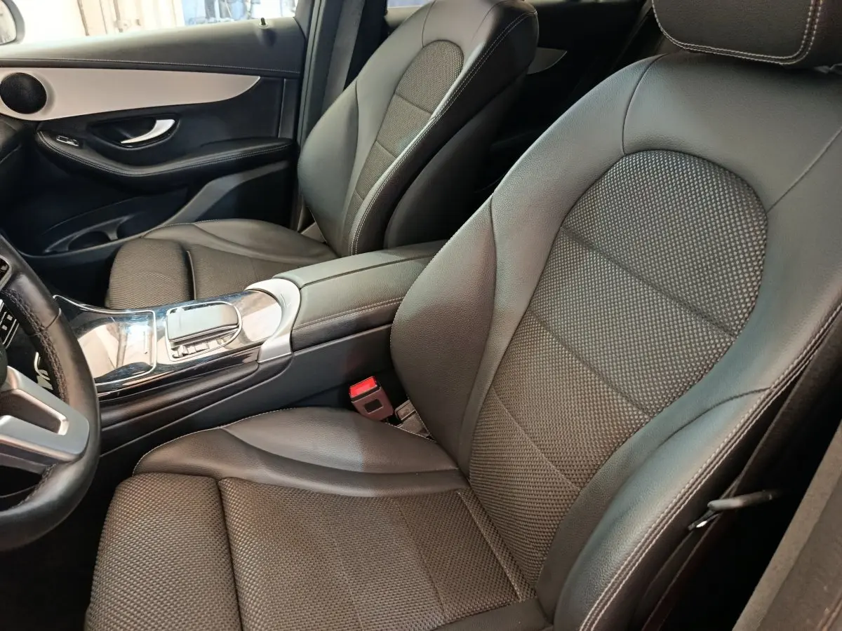 Vue intérieure côté conducteur du Mercedes GLC 300 DE Business Line 2022 avec sièges cuir noirs et console centrale brillante.