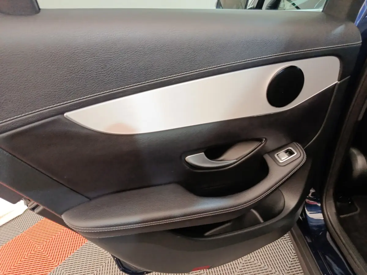 Gros plan sur la porte intérieure côté gauche d’un Mercedes GLC 300 DE Business Line bleu, avec insert aluminium et commande vitre.