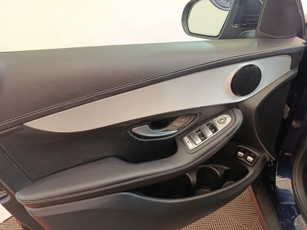 Vue intérieure côté gauche de la porte avant d’un Mercedes GLC bleu, avec garniture noire et insert aluminium.