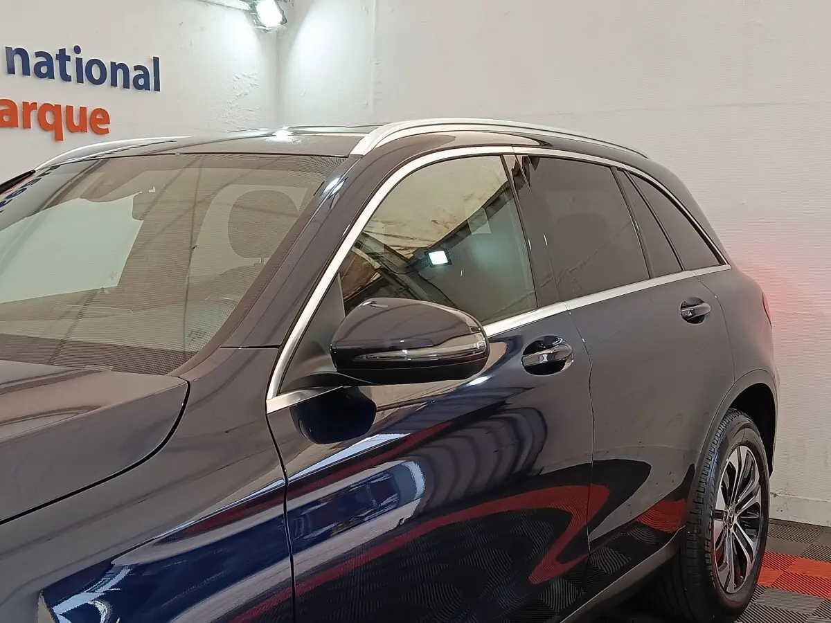 Vue latérale gauche d’un Mercedes GLC 300 DE Business Line 4MATIC bleu avec rétroviseur et jante visibles.