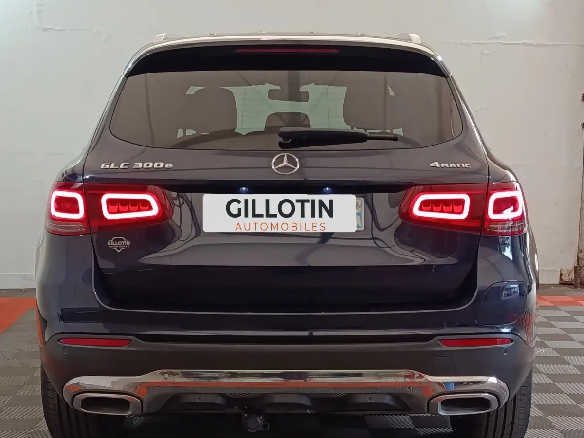 Vue arrière d’un Mercedes GLC 300 DE 4MATIC bleu avec feux LED allumés et double sortie d’échappement chromée.
