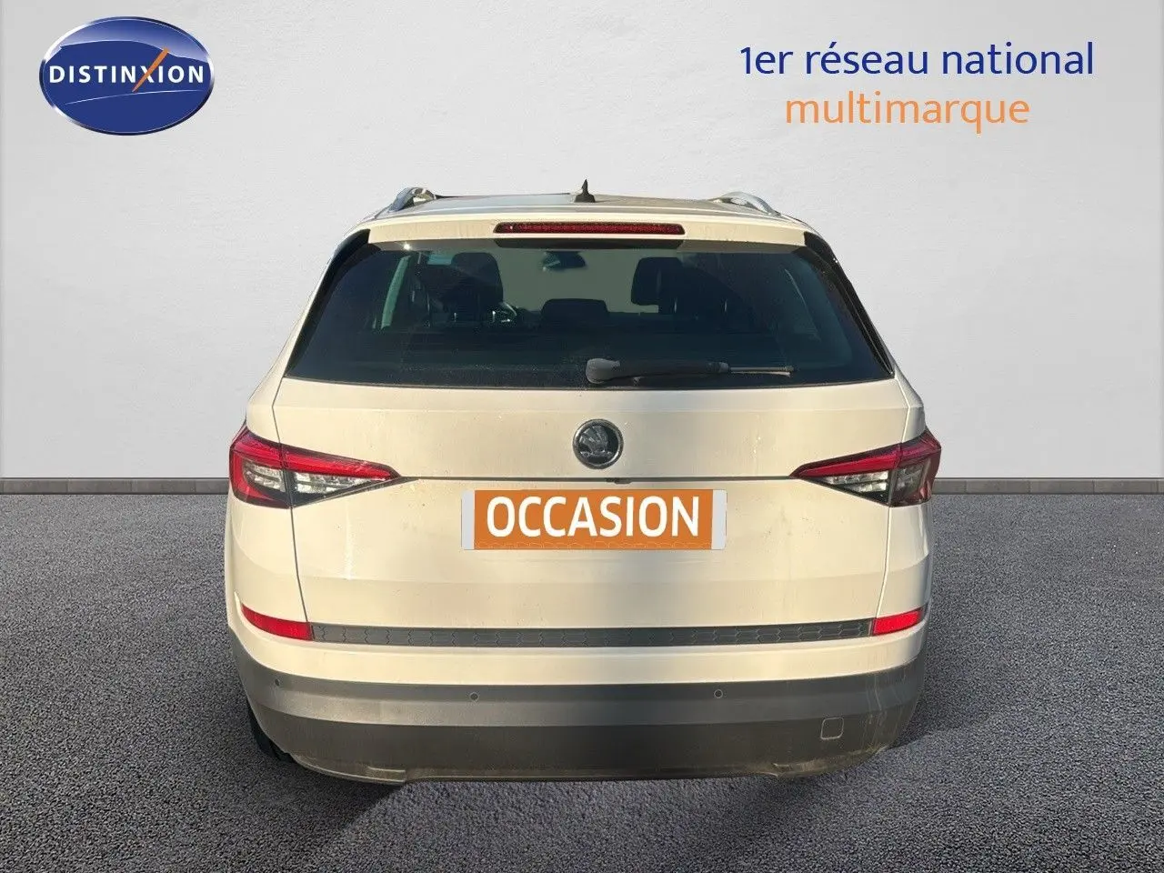 Vue arrière d'un SUV SKODA KODIAQ blanc de 2018 avec feux arrière effilés et hayon fermé sur fond neutre.