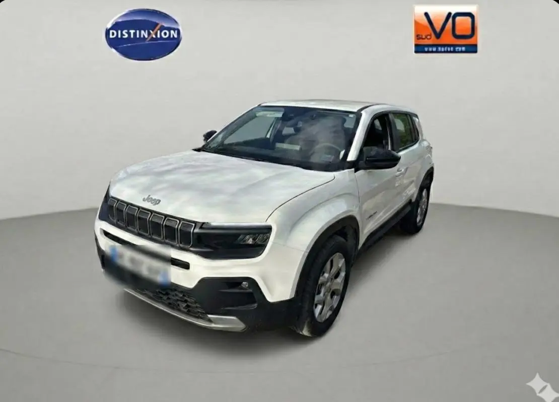 Jeep Avenger blanc en 3/4 avant droit, avec calandre noire distinctive et jantes alliage 17 pouces.