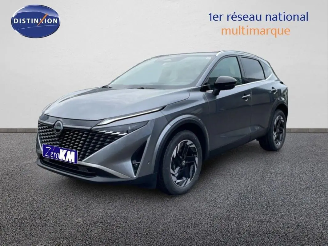 Vue 3/4 avant droit du Nissan Qashqai gris 2025 avec calandre noire et jantes au design moderne.