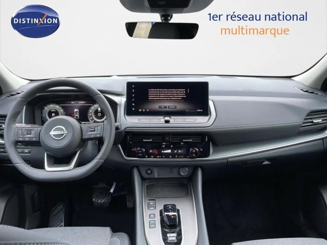 Vue intérieure frontale du tableau de bord gris du Nissan Qashqai 2025 avec écran tactile et volant multifonctions cuir.