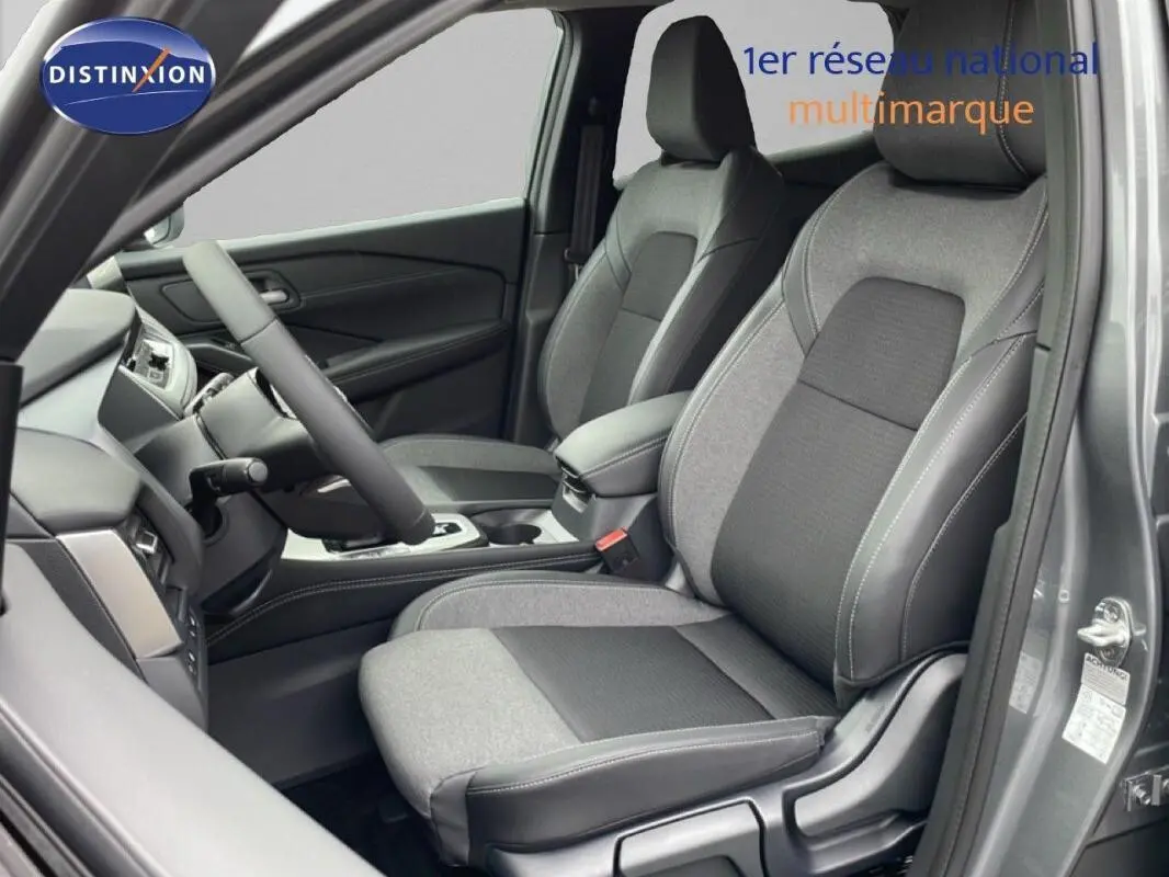 Vue intérieure côté conducteur du Nissan Qashqai gris 2025, sièges bi-matière et volant multifonctions en cuir.