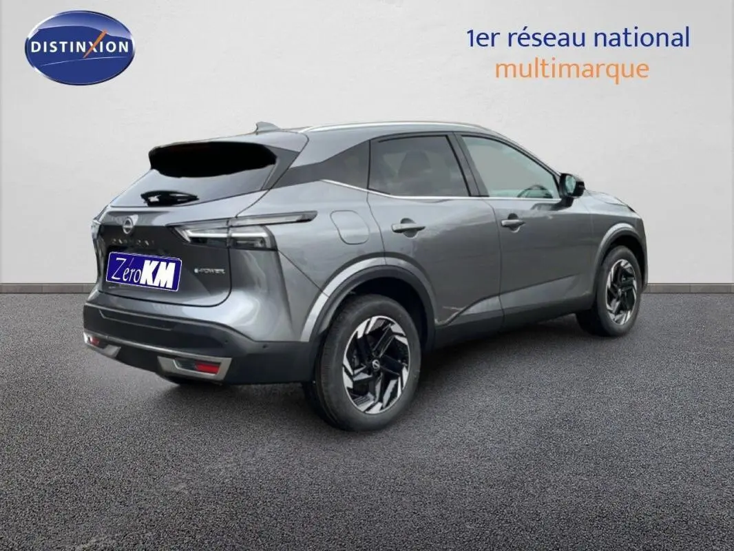 Vue 3/4 arrière droite du Nissan Qashqai gris 2025 avec jantes noires et toit noir brillant.