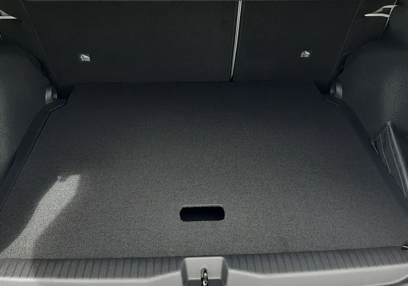 Coffre ouvert du Citroën C3 Aircross blanc banquise avec plancher plat et intérieur noir, vue de l'arrière.