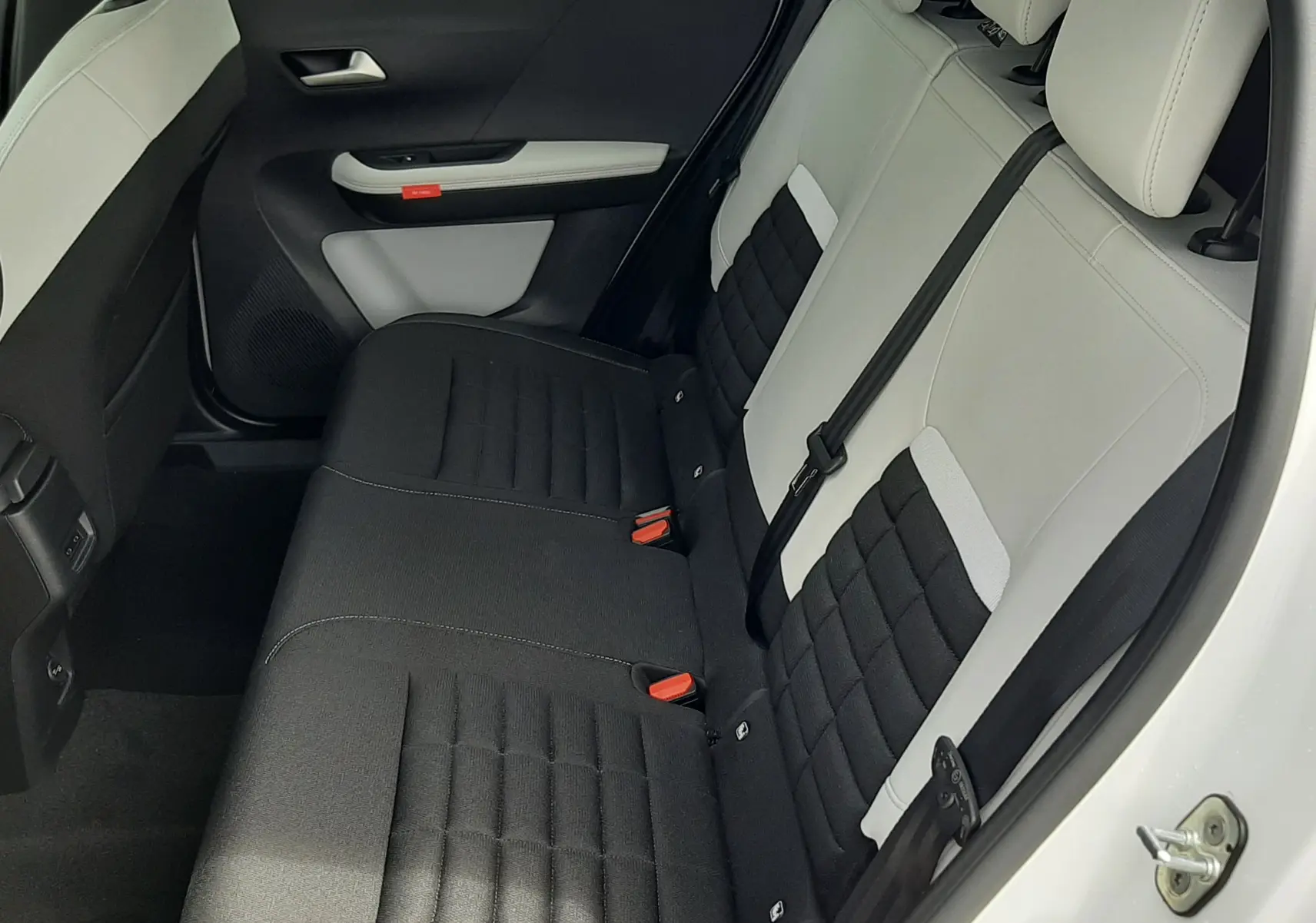 Vue intérieure côté arrière droit du Citroën C3 Aircross 2026, sièges bicolores noir et gris avec ceinture de sécurité.