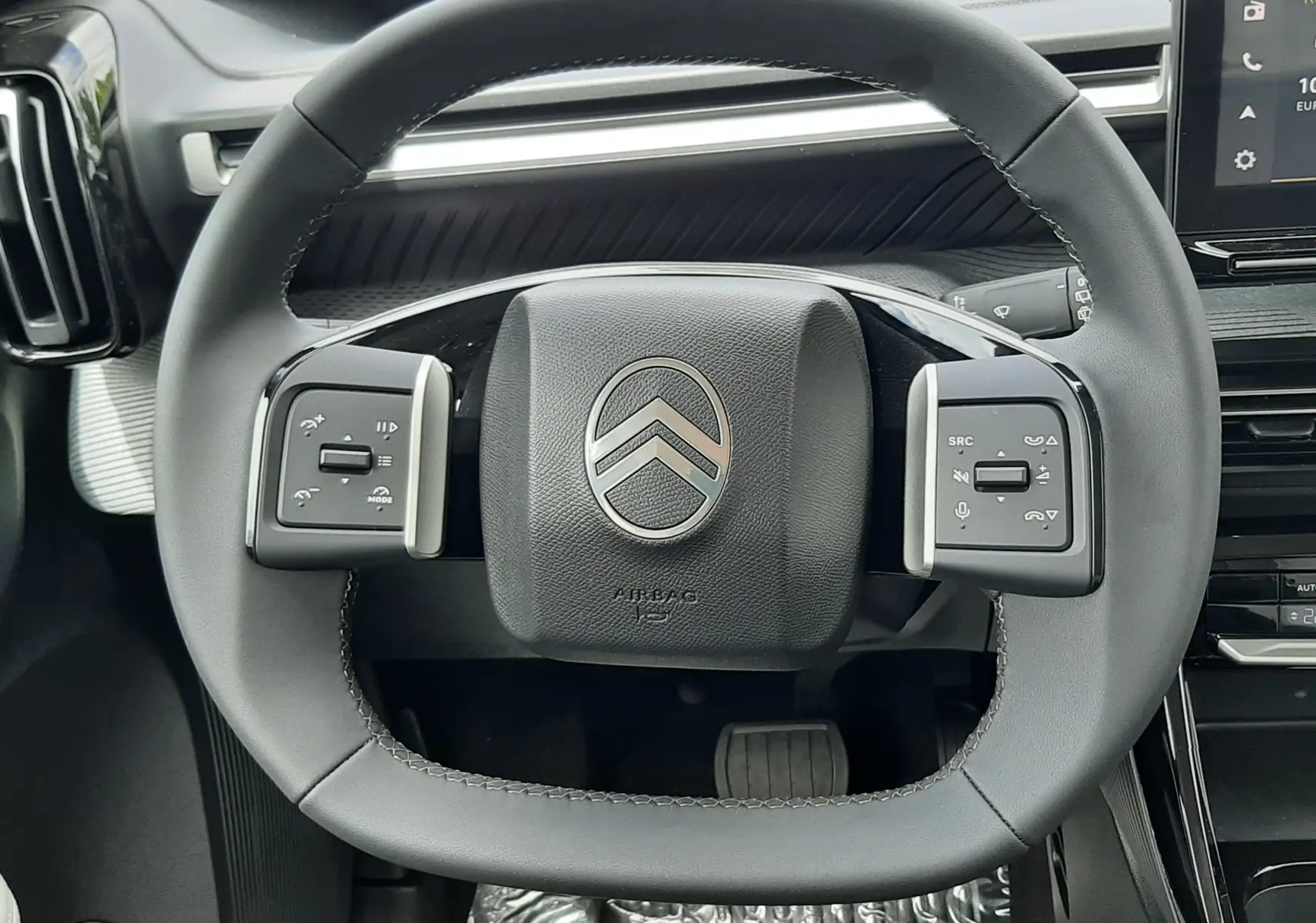 Vue rapprochée du volant noir de la Citroën C3 Aircross 2026, avec commandes intégrées et tableau de bord moderne.