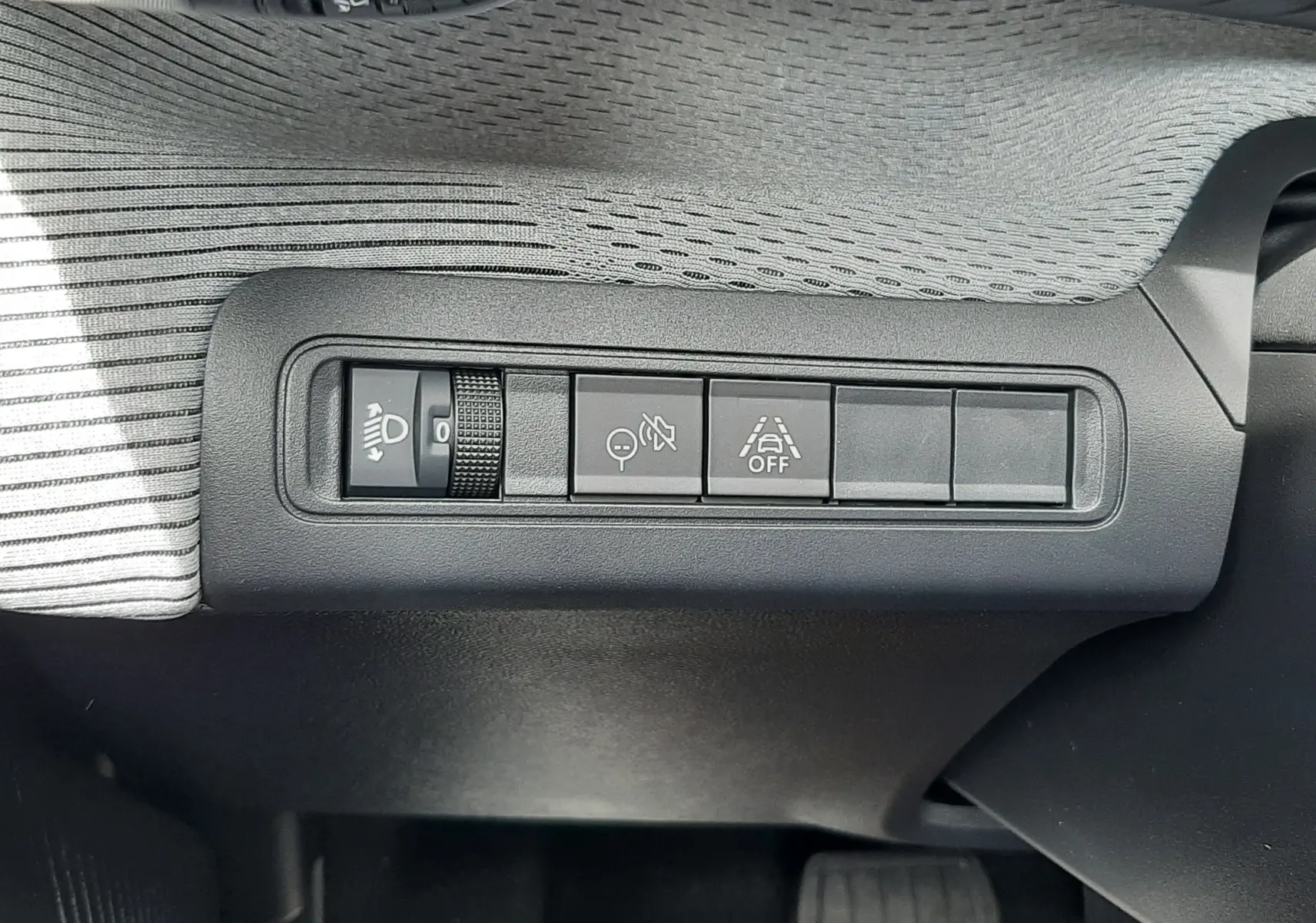 Détail intérieur des commandes de réglage d’éclairage et d’aide à la conduite sur Citroën C3 Aircross 2026 blanc banquise.