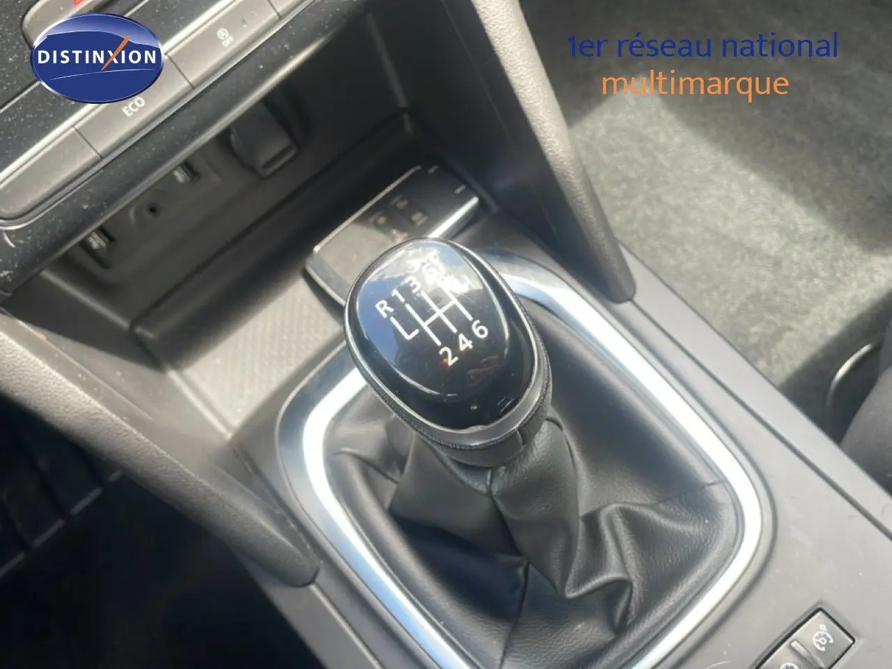 Gros plan sur le levier de vitesses manuel noir de la Renault Mégane gris titanium, avec console centrale environnante.