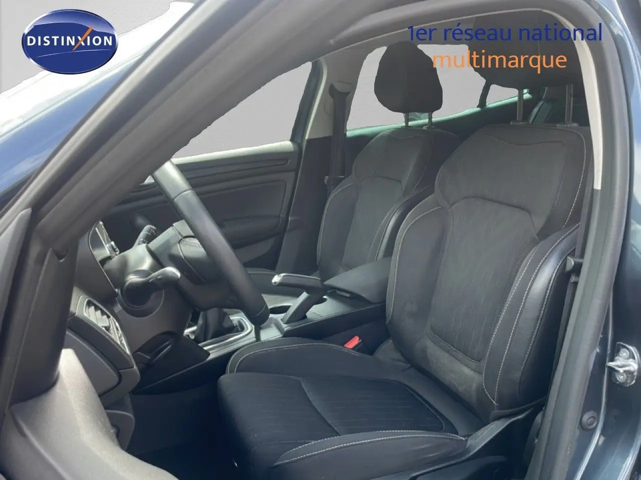 Vue intérieure côté conducteur de la Renault Mégane 2021, sièges en tissu noir avec surpiqûres contrastantes.