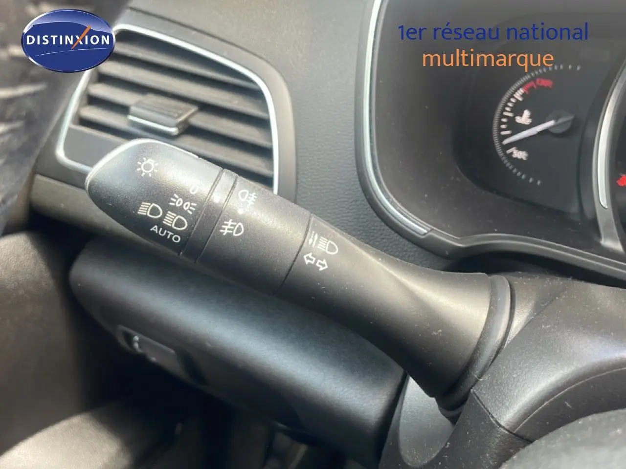 Gros plan sur la commande des phares et clignotants à gauche du volant dans l’habitacle d’une Renault Mégane gris titanium.