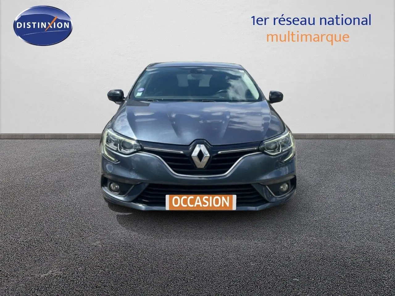 Vue frontale d'une Renault Mégane gris titanium métal avec calandre noire et phares LED allumés.