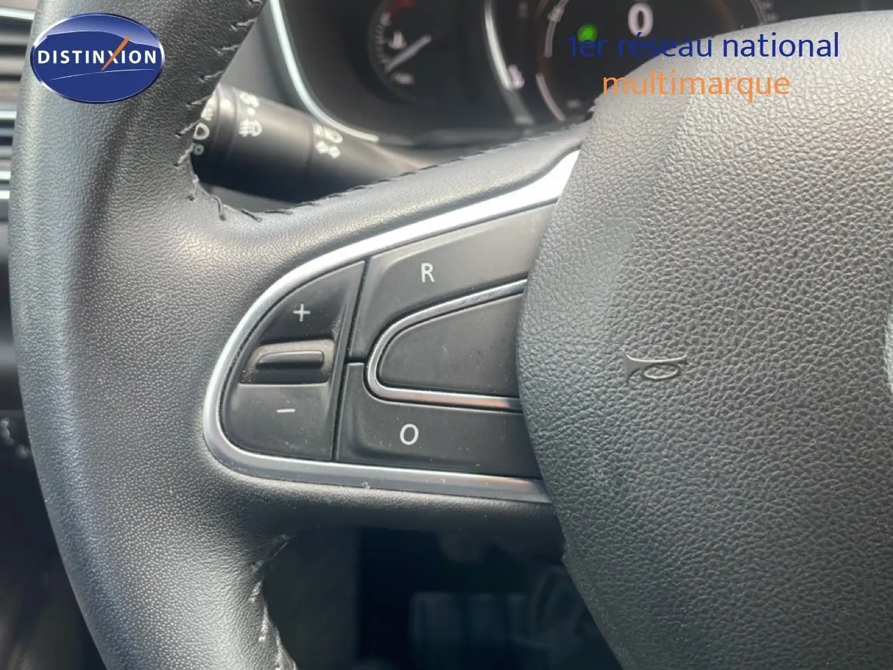 Gros plan sur le volant en cuir noir de la Renault Mégane 1.3 TCE 115ch, montrant les commandes de régulateur de vitesse.