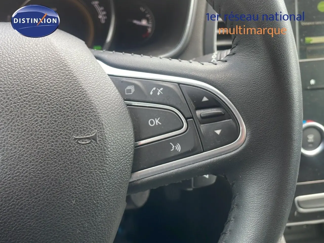 Gros plan sur le volant noir multifonction de la Renault Mégane 1.3 TCE 115CH, avec commandes intégrées visibles.