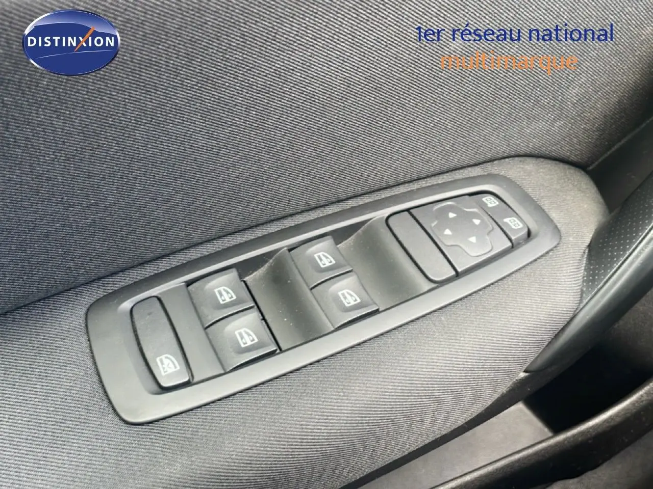 Gros plan sur les commandes des vitres électriques et rétroviseurs sur la porte côté gauche d’une Renault Mégane gris titanium.