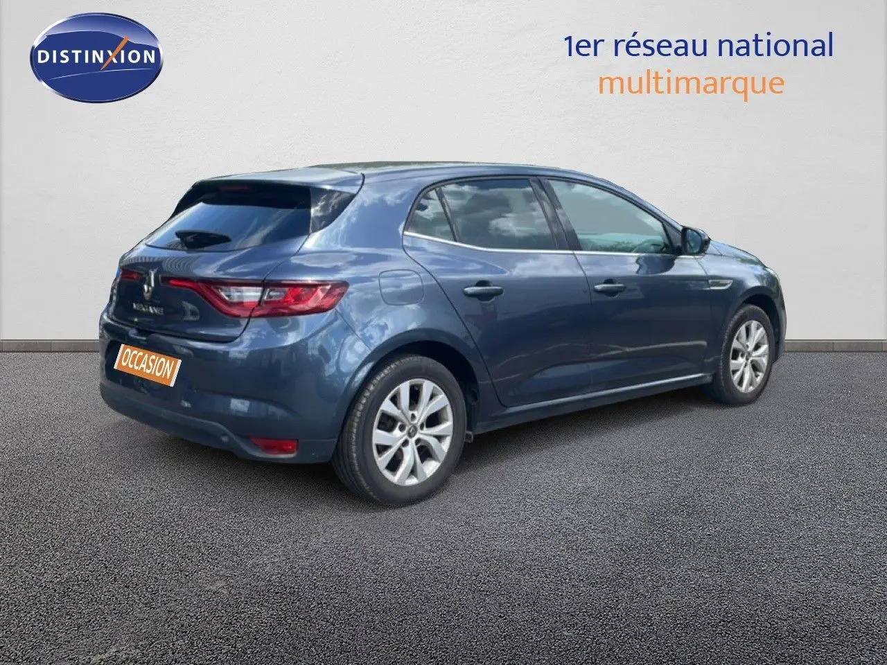 Vue 3/4 arrière droite d'une Renault Mégane gris titanium métal avec feux arrière LED et jantes alliage.