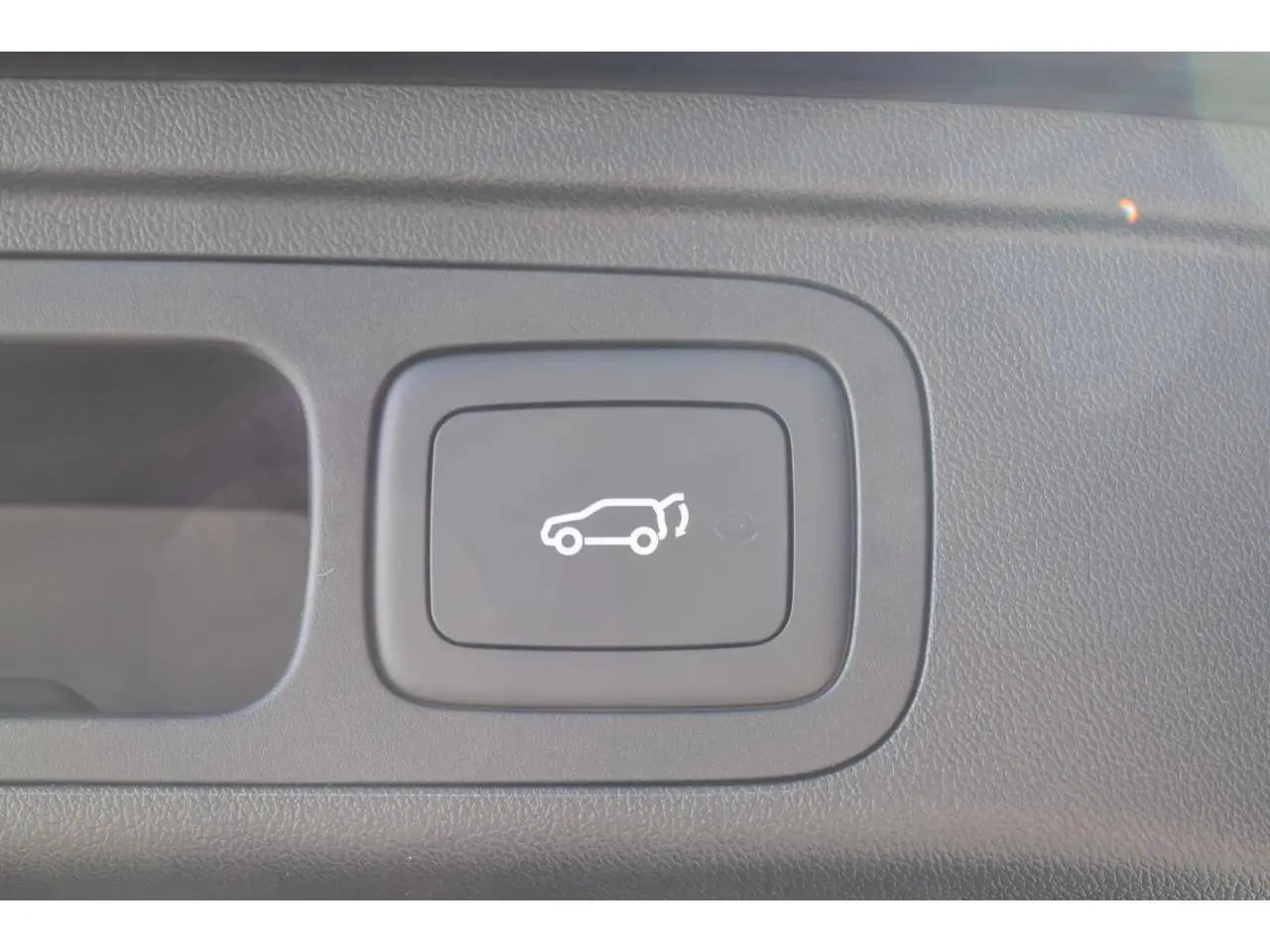 Bouton intérieur noir avec pictogramme blanc d'ouverture du hayon électrique sur MG MOTOR EHS 1.5 Hybrid+ 2026.