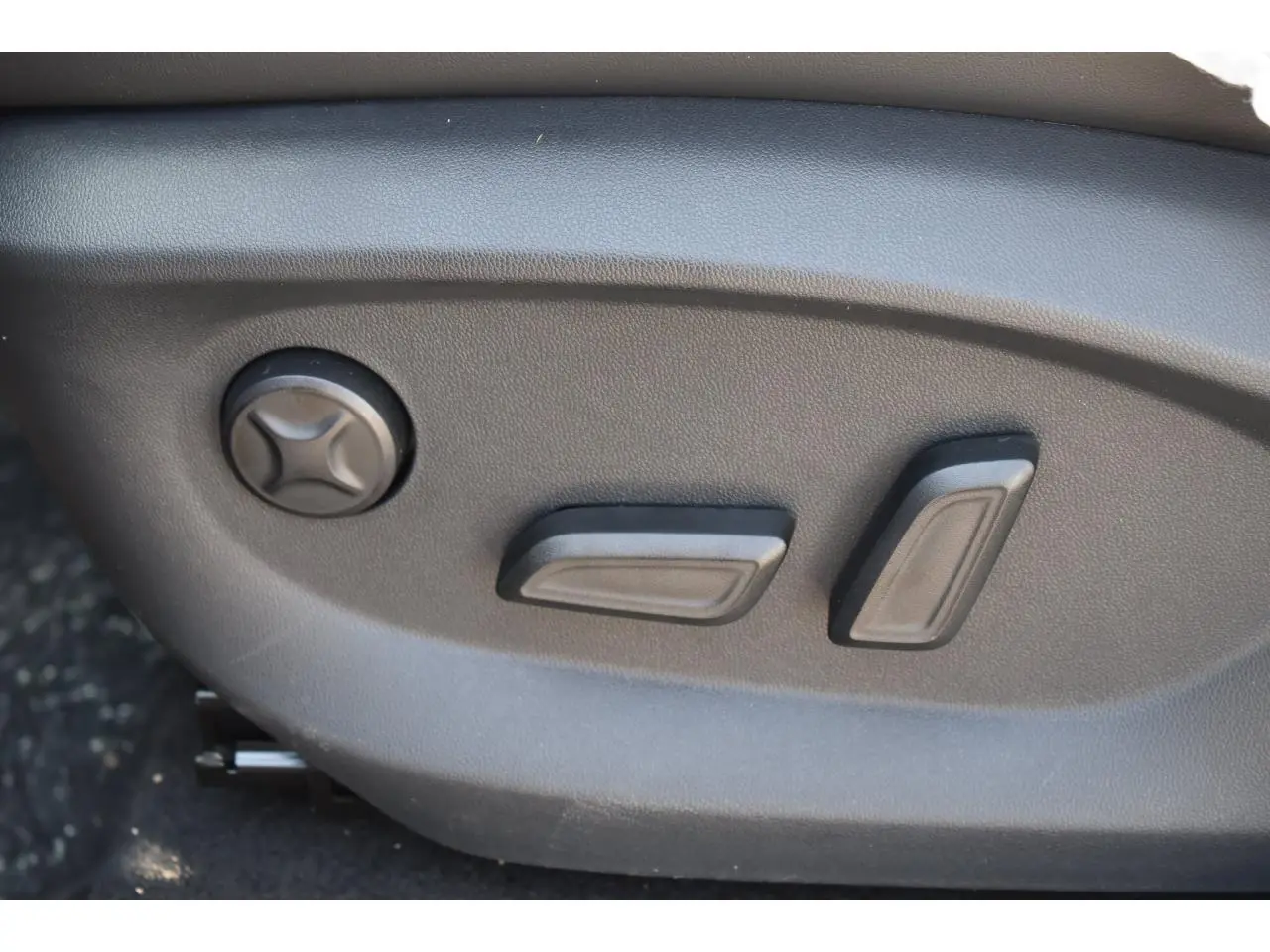 Gros plan sur les commandes de réglage électrique du siège conducteur du MG MOTOR EHS 1.5 Hybrid+ noir, version 2026.