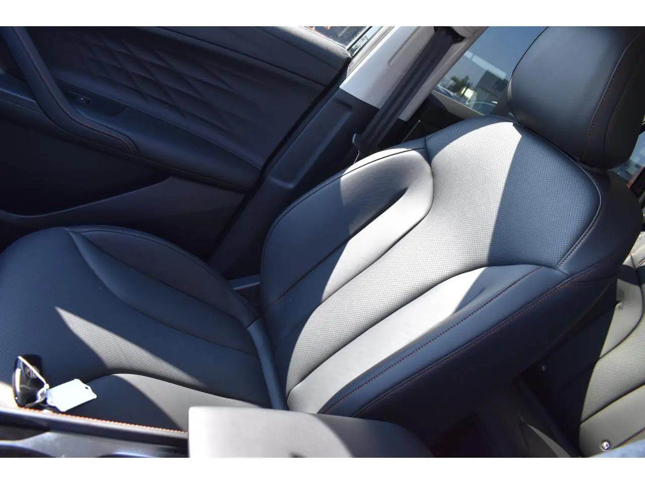 Gros plan sur le siège avant droit en cuir noir avec surpiqûres marron du MG MOTOR EHS 1.5 Hybrid+ Luxury 2026.