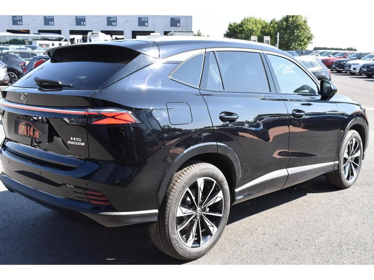 Vue 3/4 arrière droite du MG Motor EHS noir 2026 avec jantes alliage 19 pouces et feux arrière LED distinctifs.